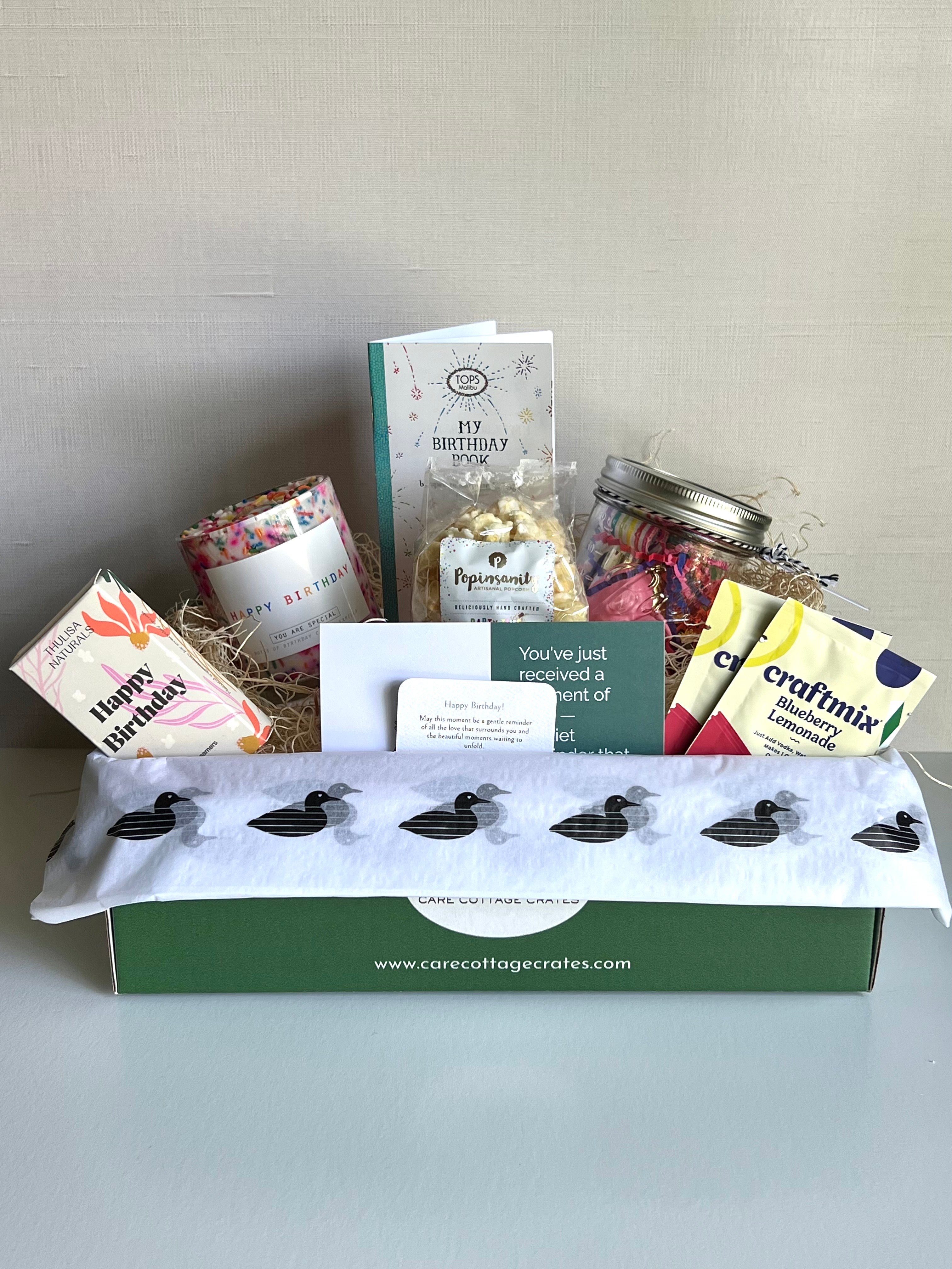 Birthday celebration in a box. Shower steamers, Birthday candle, Birthday book/card, Birthday popcorn, Birthday Party Kit, Craftmix cocktail/mocktail mix. Includes a thoughtful prompt and a curated playlist to encourage a mini birthday celebration.