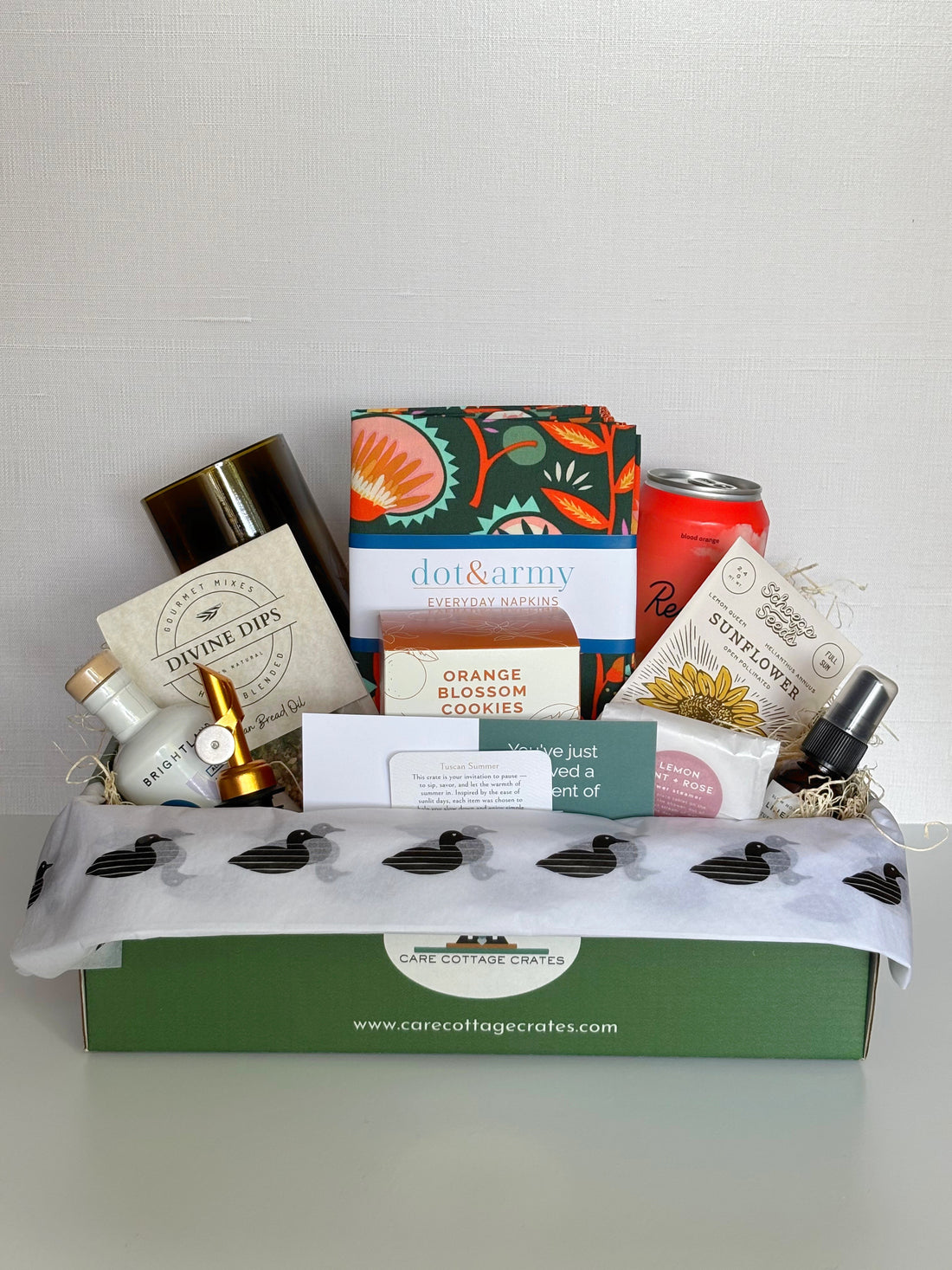 Image of a Gift Basket with olive oil, spout, dip mix, handcut glass, napkins, recess blood orange drink, orange blossom cookies, sunflower seeds, Lemon mint and rose shower steamer, and tuscan summer spray.