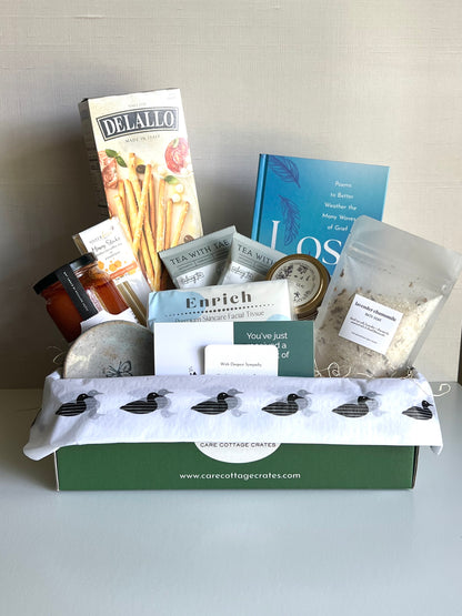 Tomato Soup, Breadsticks, Honey Sticks, Calming Tea, Lilac Candle, Bath Soak, Loss Book, Facial Tissue, Trinket Dish. Includes a thoughtful prompt and curated playlist built to encourage a bit of peace in a very tricky time of grief or loss.
