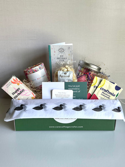 Birthday celebration in a box. Shower steamers, Birthday candle, Birthday book/card, Birthday popcorn, Birthday Party Kit, Craftmix cocktail/mocktail mix. Includes a thoughtful prompt and a curated playlist to encourage a mini birthday celebration.